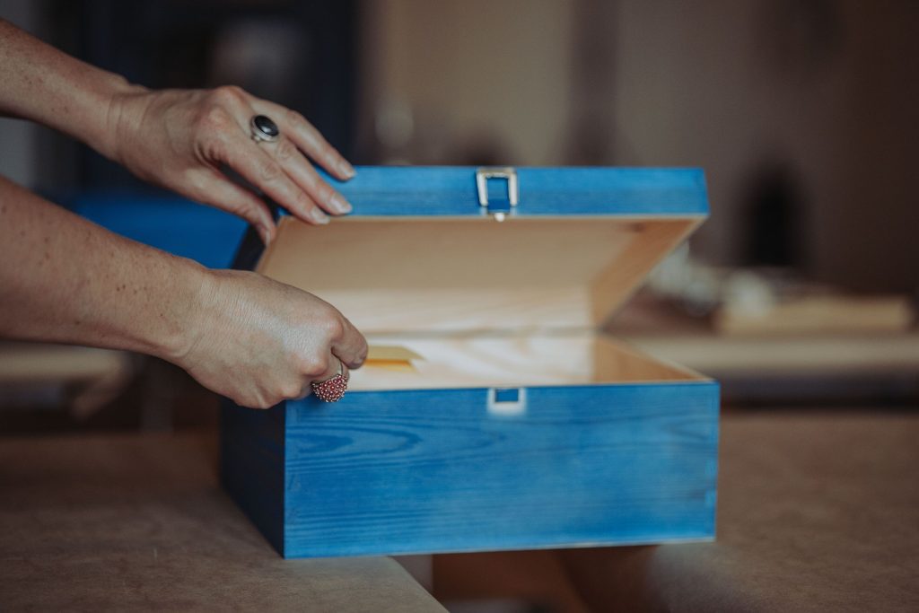 Eine Person wirft eine Erinnerung in eine blaue Box.